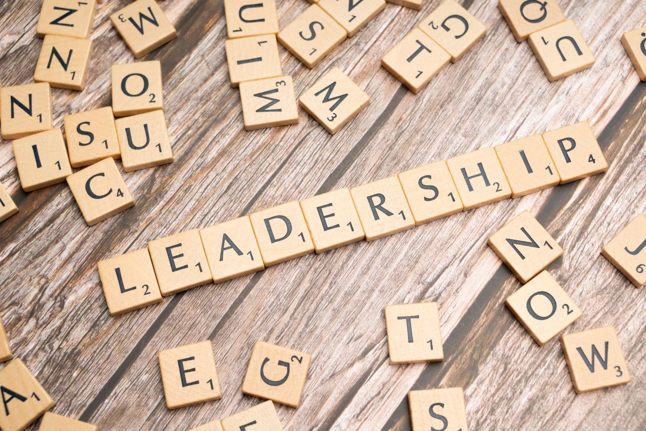 Wooden letter tiles spelling LEADERSHIP on a wooden surface, symbolizing leadership qualities and skills.